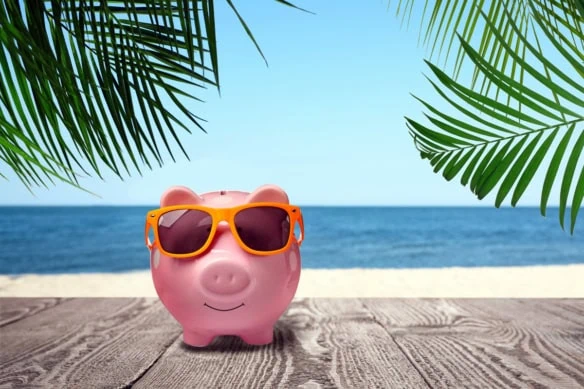a piggy bank wears sunglasses while standing on a boardwalk.