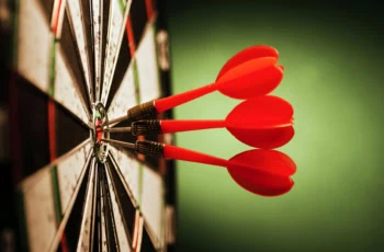 three darts in the bullseye of a target.