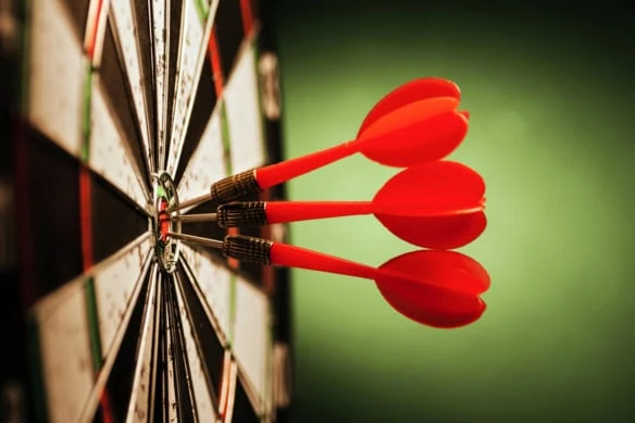three darts in the bullseye of a target.
