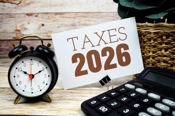 a sign that says taxes 2026 next to a clock and calculator.