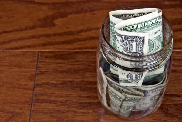 a jar filled with one dollar bills.