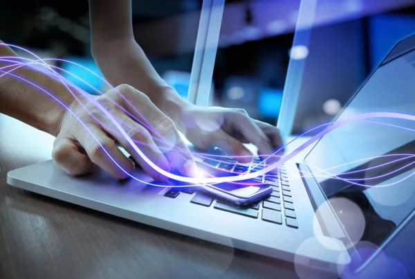 concept art of a purple light beam moving across a person's hand and onto their laptop.