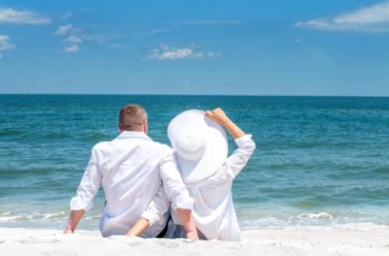 early retirement beach couple white hat
