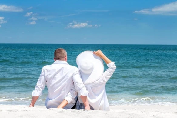 early retirement beach couple white hat