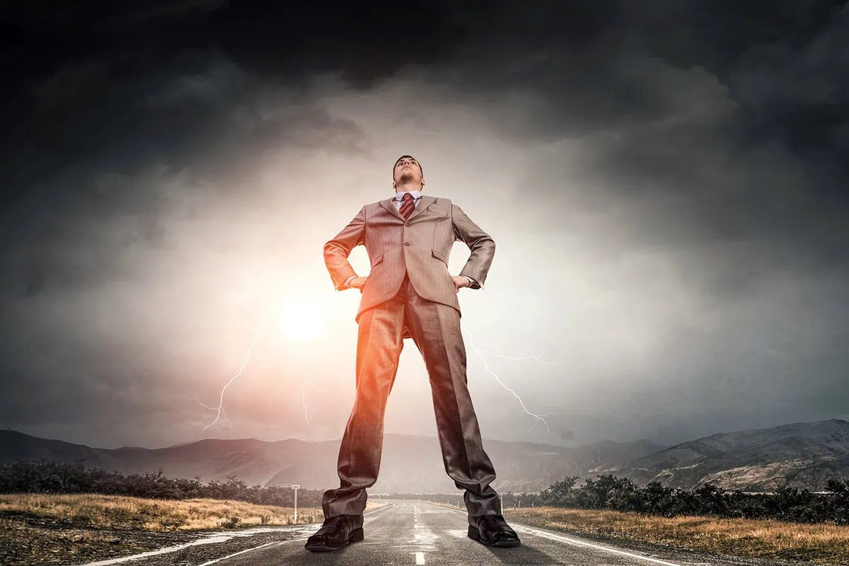 The 16 Best ETFs to Buy for the Rest of 2026 3 a giant businessman stands with each foot on a different side of the road.