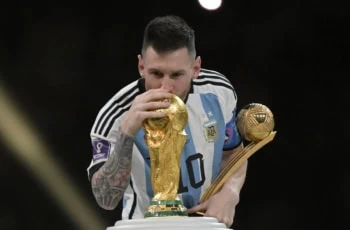 Argentine forward Lionel Messi kisses a World Cup trophy in 2022 in Qatar.
