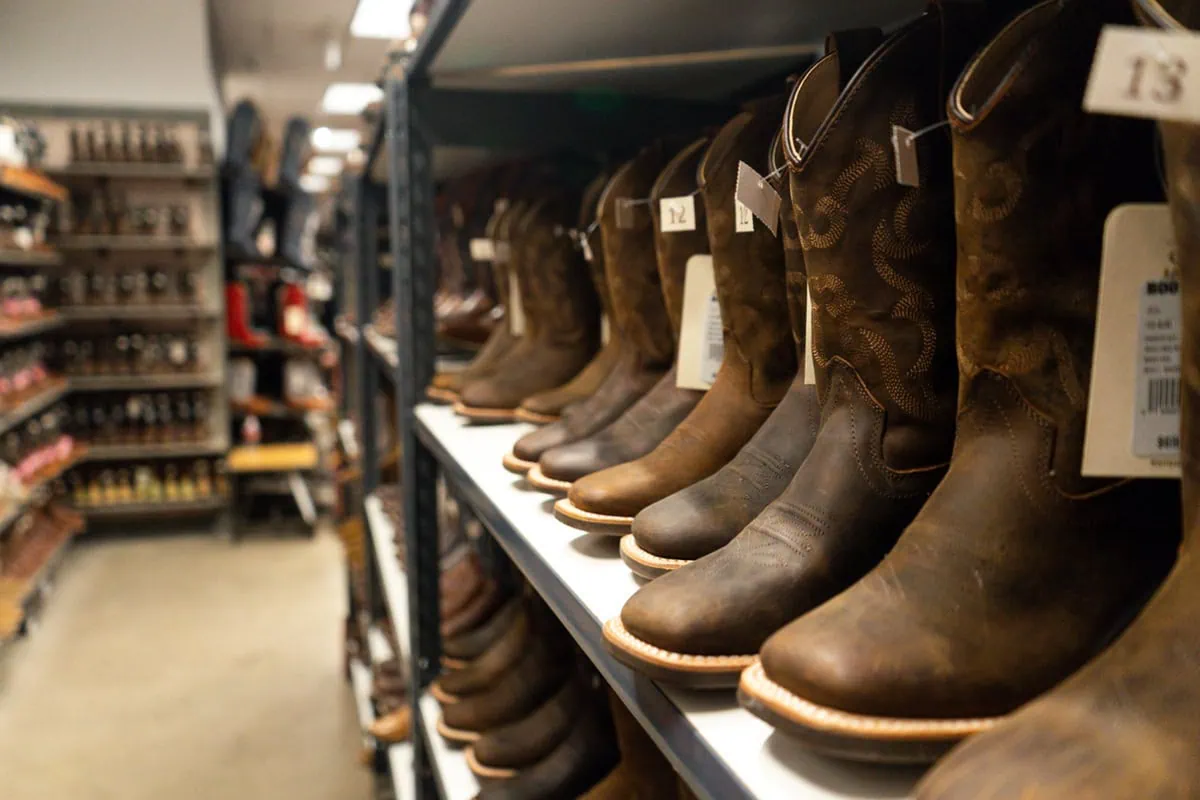 10 Best 'Rebound' Stocks to Buy for the Rest of 2026 12 Rows of boots at a Boot Barn store.