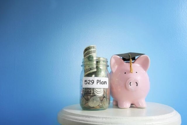 529 plan jar and piggy bank wearing graduation cap