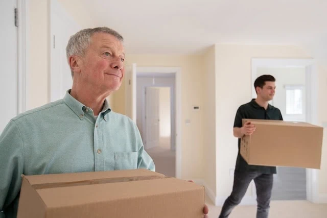 adult child moving home with elderly father in foreground 640