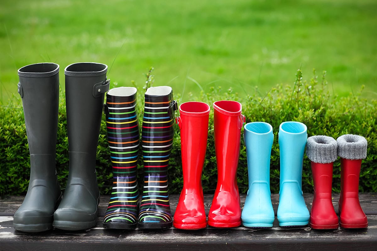 several different sized and styled pairs of galoshes sitting on a mat.