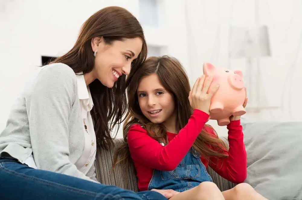 mother paying allowance for kids to daughter piggy bank