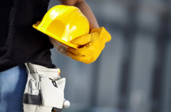 a construction worker holds a hard hat.