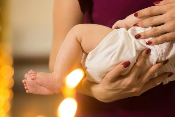 baby legs on the hands of godparents in the cathedral