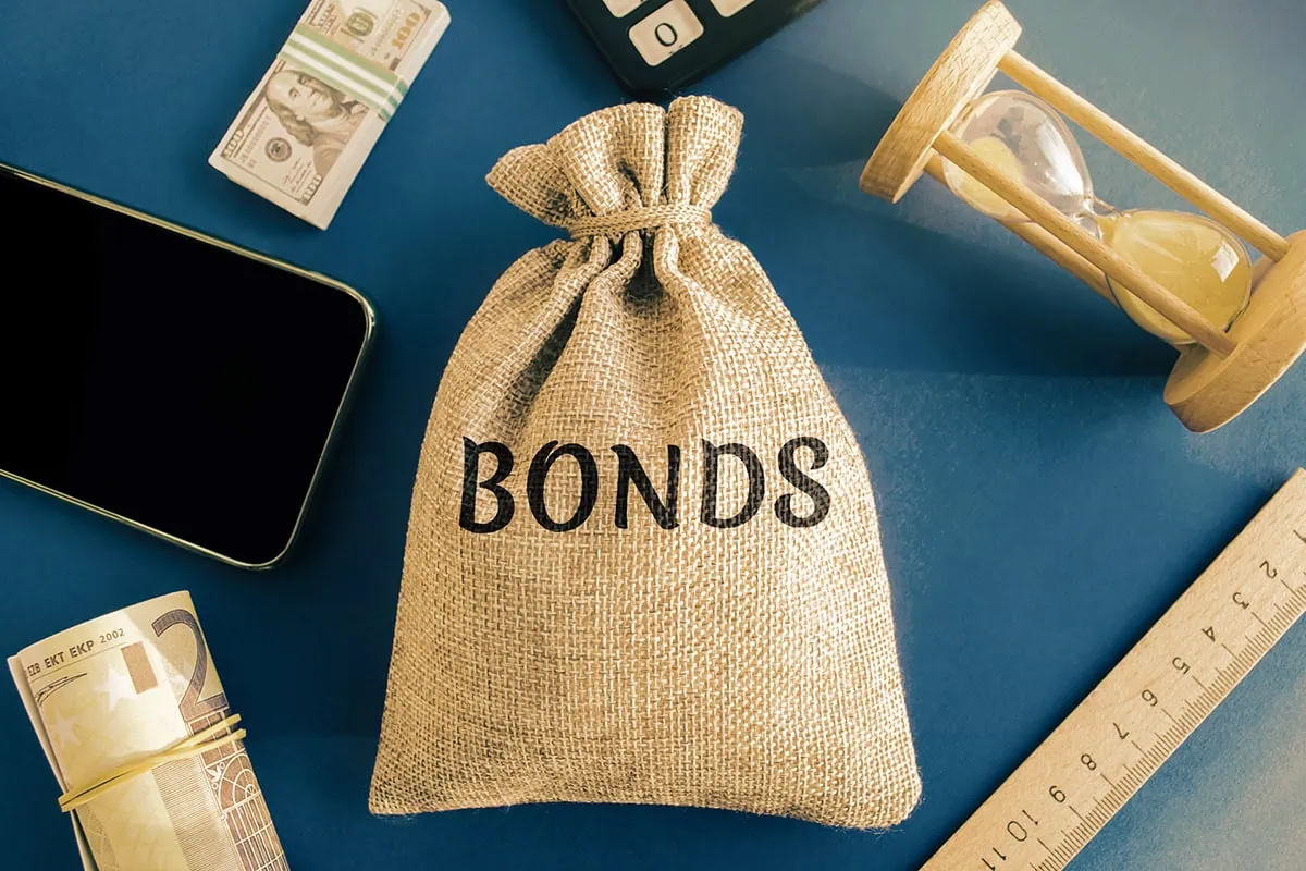 The 16 Best ETFs to Buy for a Prosperous 2026 10 a money bag with the word bonds printed on it.