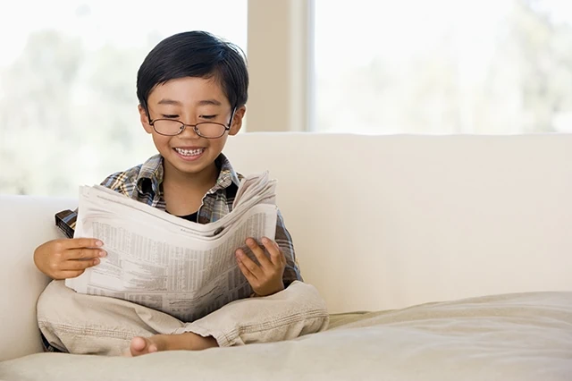 child reading newspaper kid financial education