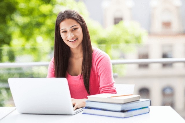 college student with computer and books