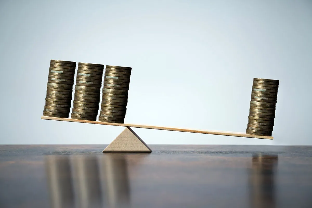 Wall Street Loves These 10 Dividend-Growth Stocks 3 a balance with one stack of coins on one side and three stacks on the other.