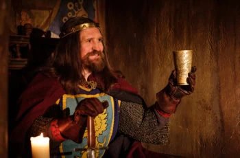 a king lifts his cup in celebration.