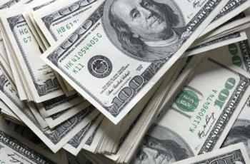 hundred dollar bills stacked and swirled across a table.