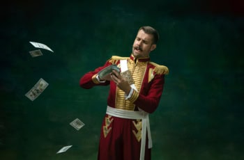 a man dressed up as a king making it rain with dollar bills.