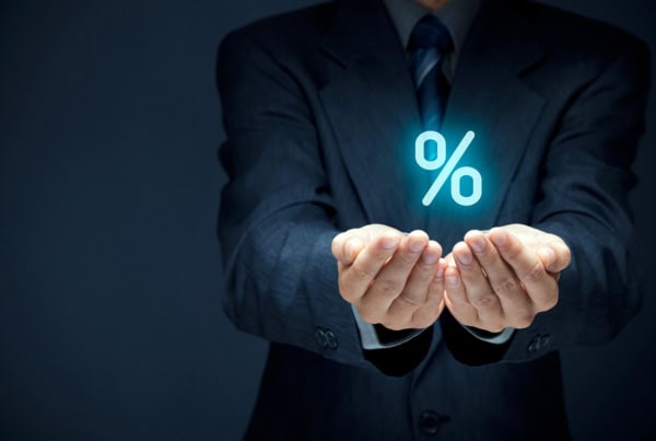 a businessperson cups his hands and a virtual percent sign floats above them.