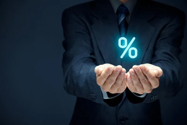 a businessperson cups his hands and a virtual percent sign floats above them.
