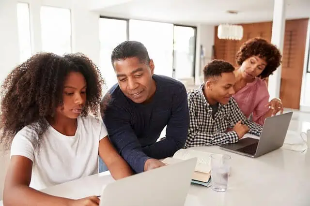 family looking at laptops together