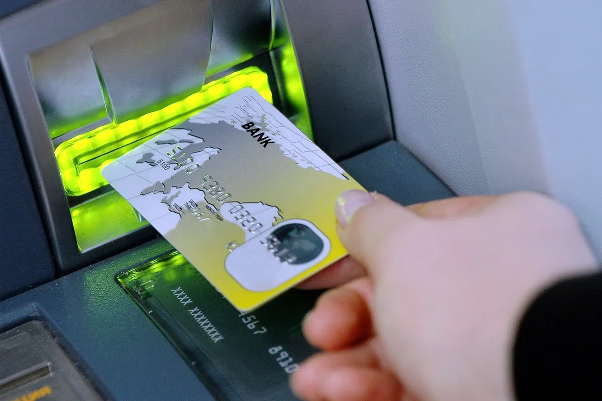 10% APR Cap on Credit Cards? Wall Street Says It’s Unlikely. 3 a person puts a debit card into an ATM.