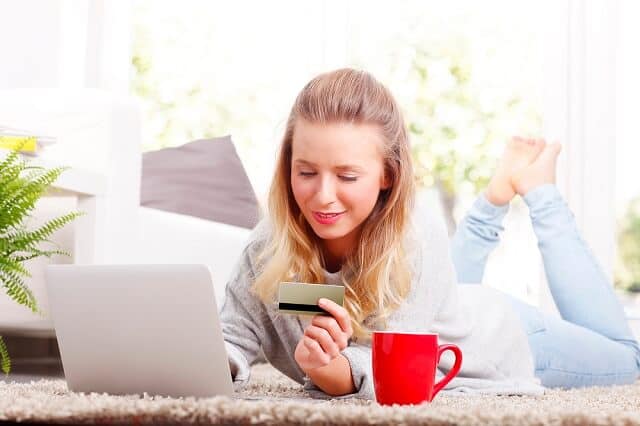 girl at laptop with debit card making purchase