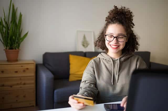 girl smiling with prepaid card in hand