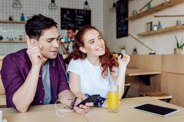 happy couple listening to music coffee shop