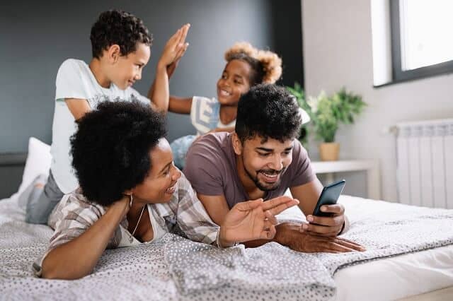 happy family on the bed with smartphone