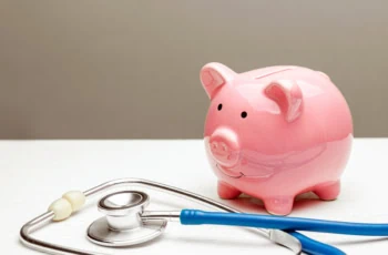 a piggy bank next to a stethoscope.