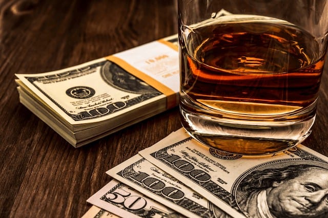 how to invest in whiskey glass dollars money