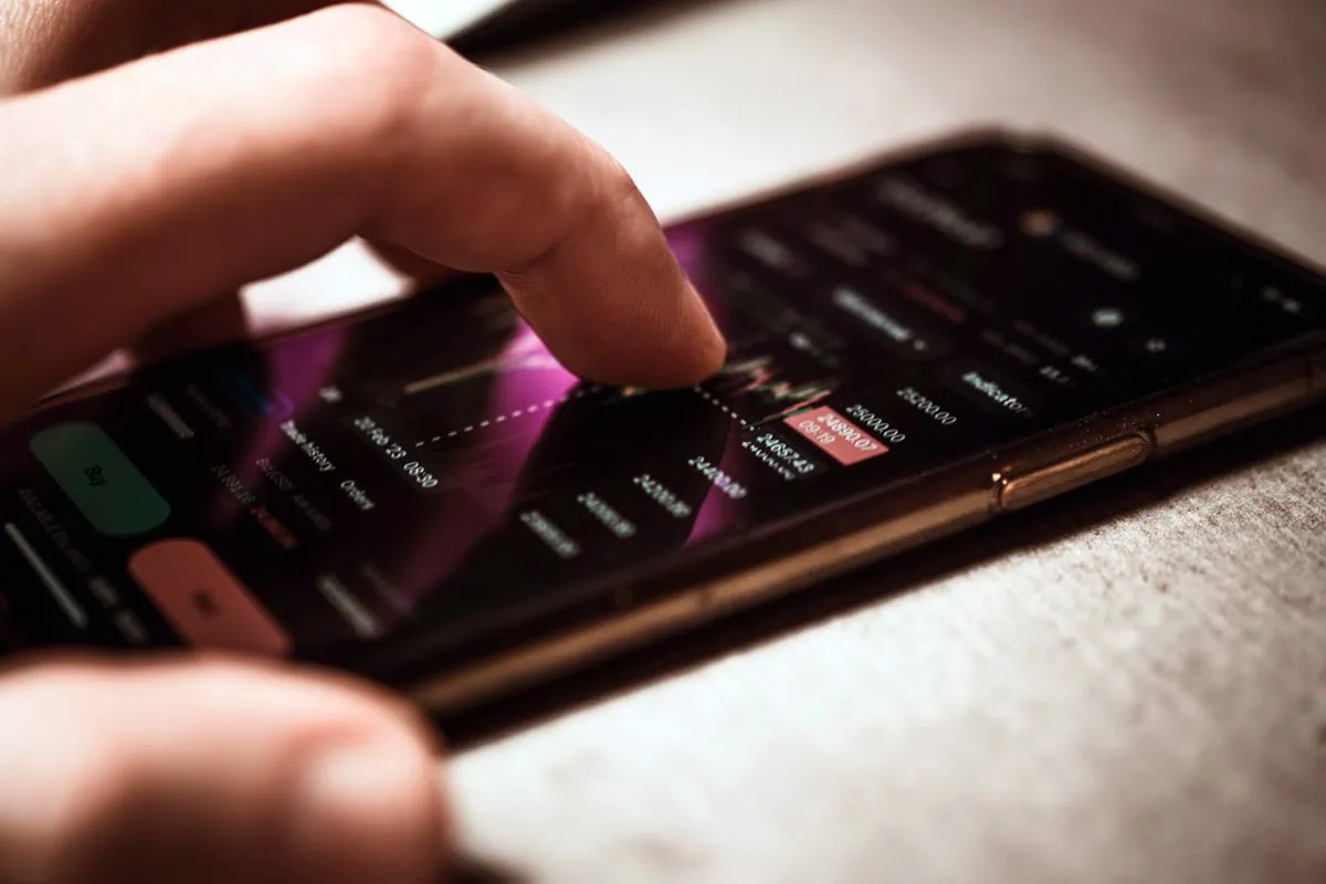 What Is FIRE? A Beginner's Guide to the Early Retirement Movement 7 a person invests on a smartphone app.