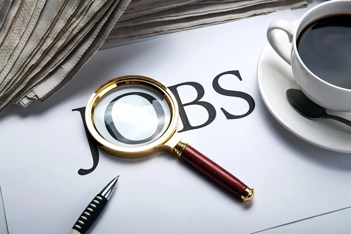 a magnifying glass rests over the "O" in the word "jobs."