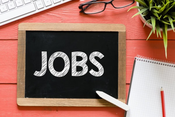 the word jobs is written on a personal chalkboard sitting on a desk.