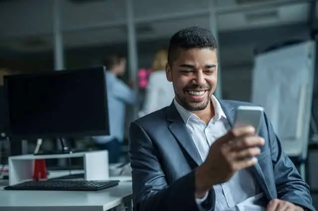 man checking his phone with elation