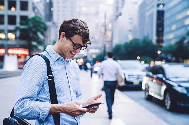 man looking at his phone happy