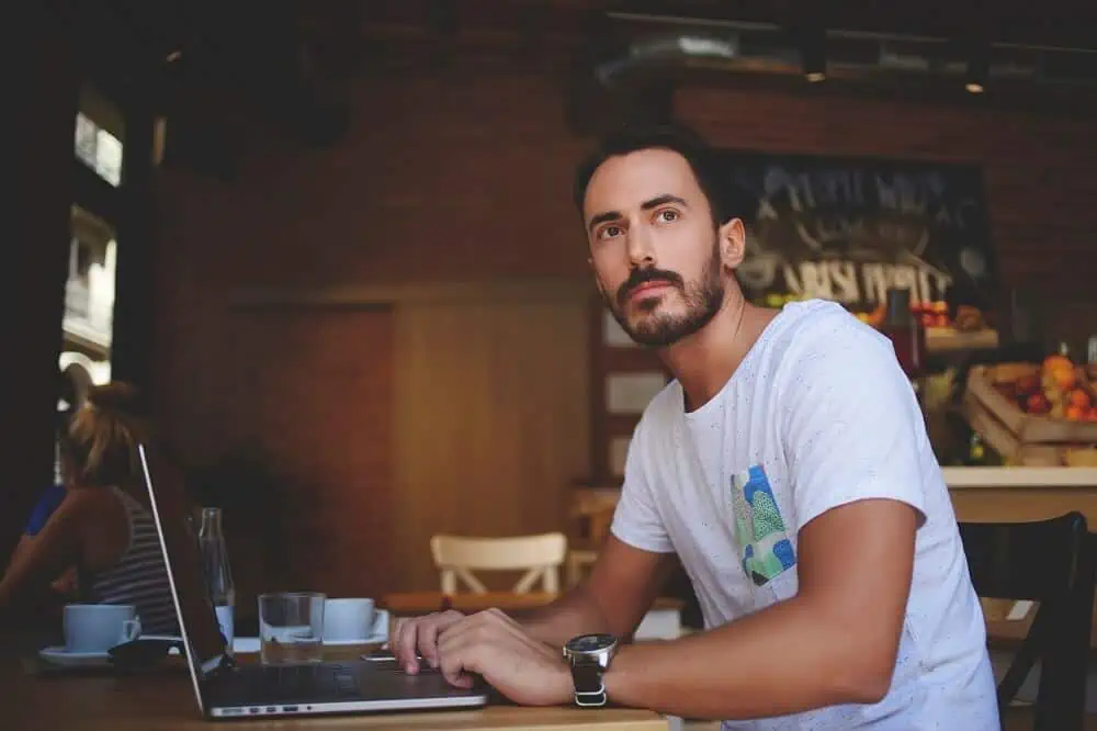 man sitting at laptop thinking