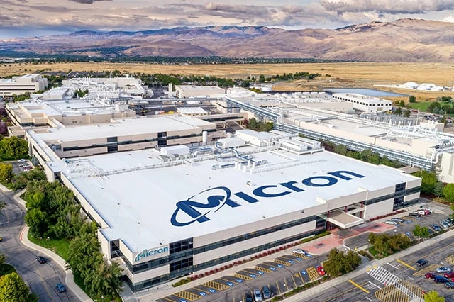 a micron technology facility in boise idaho shot from far away with the mountains in the background.