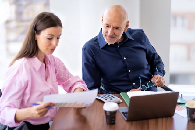 middle aged man meeting with financial advisor to look at chart 640