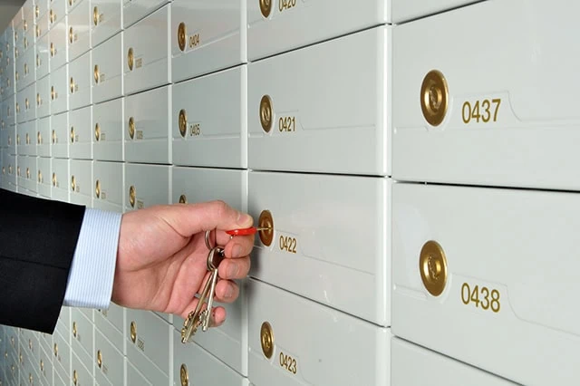 7 Best Fidelity Funds to Hold in an HSA 5 a businessman opens a safe deposit box at a bank.