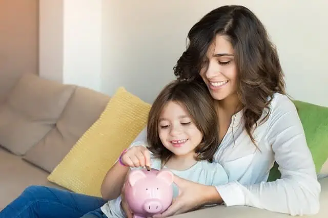 mother and daughter saving piggy bank