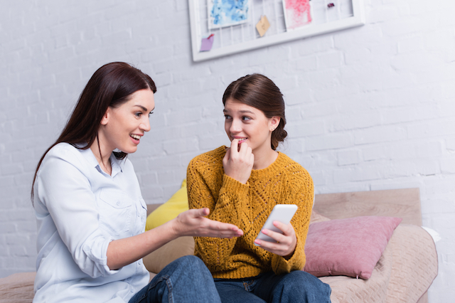 mother teen daughter smartphone