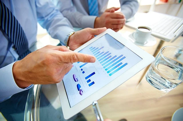 10 Monthly Dividend Stocks for Frequent, Regular Income 25 a fund manager looks at a set of charts for a mutual fund.