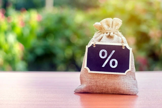 8 Best T. Rowe Price Funds to Buy for 2026 8 a sack of money with a percent sign chalkboard hanging on it from its neck.