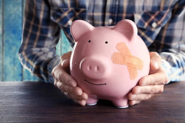 piggy bank injured bandage wasting wealth 640