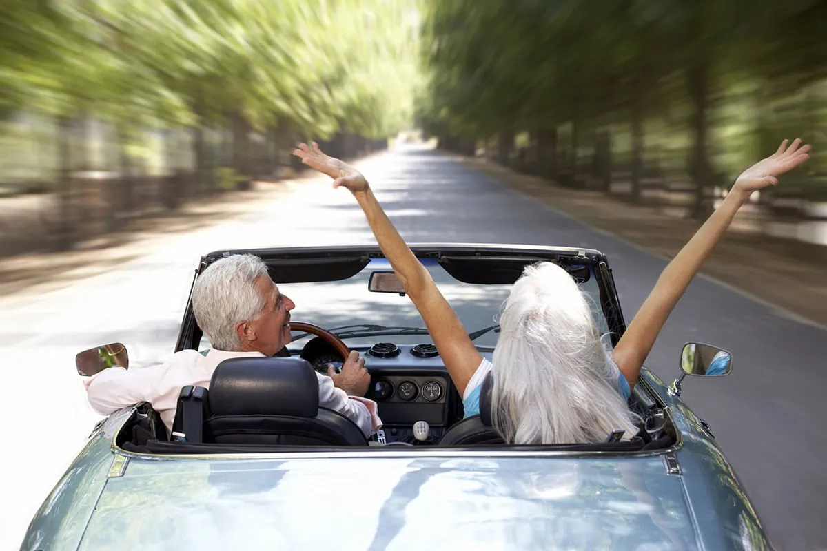 5 Things Retirees Can Do With Their Cars 2 a senior man and woman drive around in a convertible.