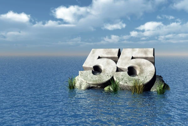 the number 55 carved out of rock floating in the ocean.